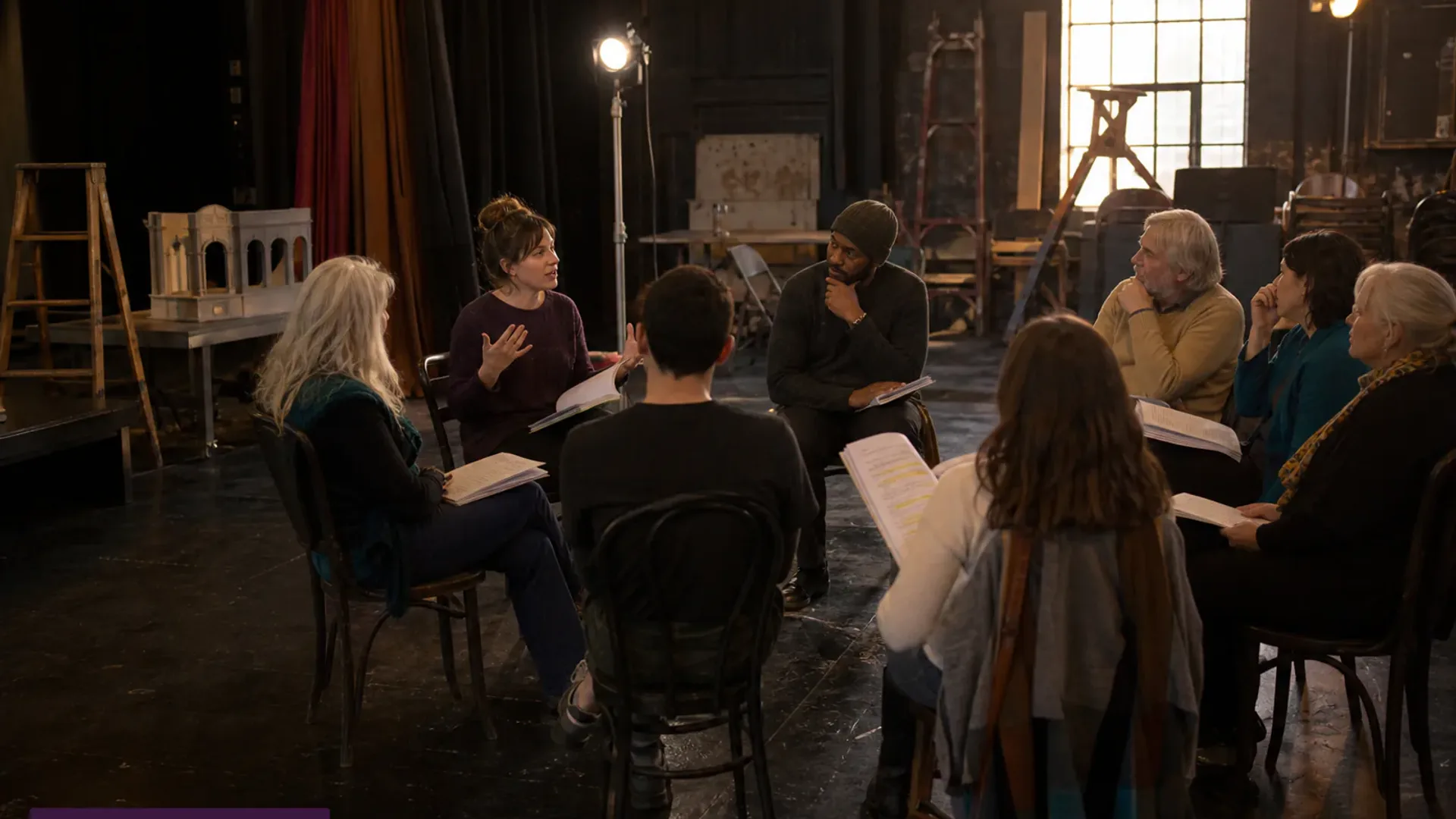 Community theatre artists collaborating in a rehearsal space.